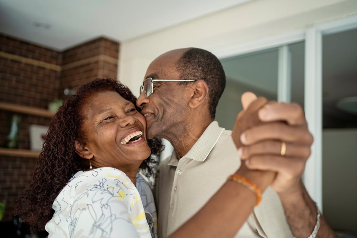 African American senior couple dancing joyfully on the balcony